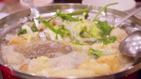 Detail-of-chopsticks-removing-vegetables-from-a-boiling-sukiyaki-pot