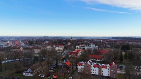 Aerial-dolly-establish-of-small-European-town-in-winter-with-snow,-leaves-off-of-trees