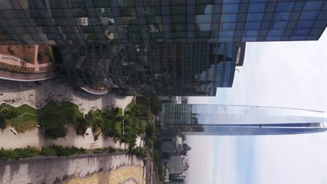 Aerial-View-Of-Reflective-Office-Skyscraper-With-Dolly-Right-To-Reveal-Gran-Torre-Santiago-In-Background