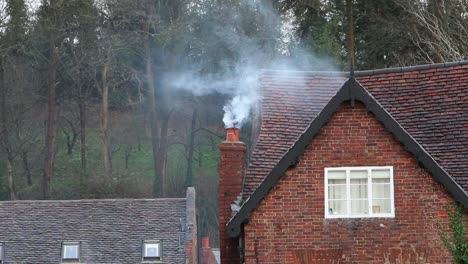 Smoke-rising-from-a-domestic-chimney-on-an-old-house