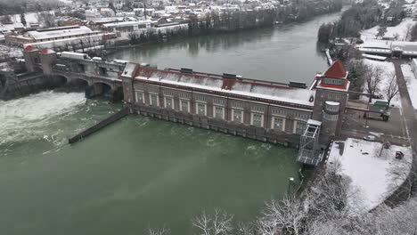 Backwards-drone-dolley-shot-of-a-traditional-hydro-power-plant-in-winter-time-at-the-Rhine-in-Germany