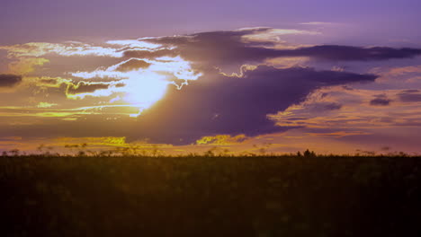 Golden-sunrise-cloudscape-over-a-farmland-field---time-lapse