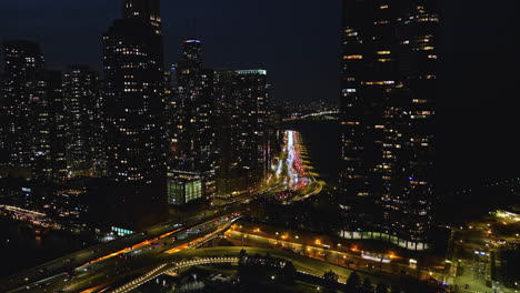Traffic-in-front-of-night-lit-high-rise-of-Streeterville-in-Chicago---Aerial-view
