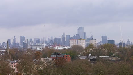 Grey-clouds-rush-above-London-city-skyline-as-smoke-steams-out-of-stacks-and-chimney