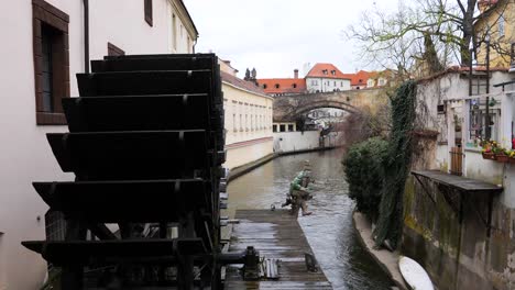 Houses-along-the-Devil´s-Stream-and-the-wooden-wheel-of-Grand-Priory-Mill-Prague,-Czech-Republic