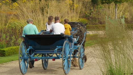 Vater-Und-Kinder-Auf-Einer-Blauen-Pferdekutsche-In-Trentham-Gardens-An-Einem-Sonnigen-Tag