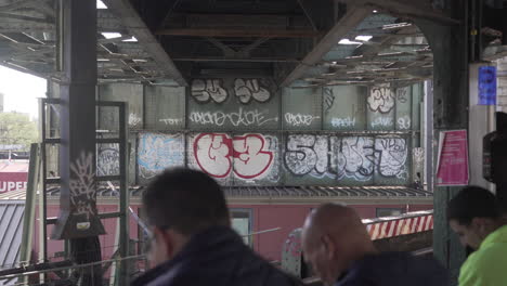 Viajeros-Esperando-El-Tren-En-Una-Estación-De-Graffiti