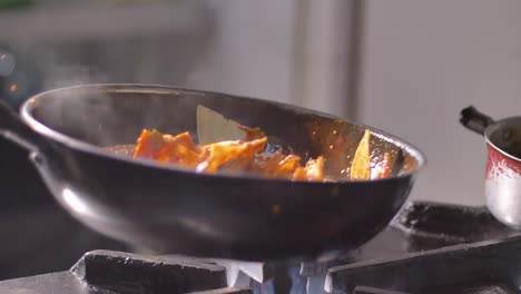 Tortilla-chips-with-hot-salsa-in-frying-pan-on-burning-fire-in-slow-motion