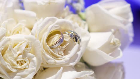 Bouquet-of-white-roses-with-wedding-rings-between-their-petals