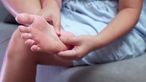 Close-up-of-woman-pressing-and-squezzing-her-own-foot-while-giving-herself-a-foot-massage