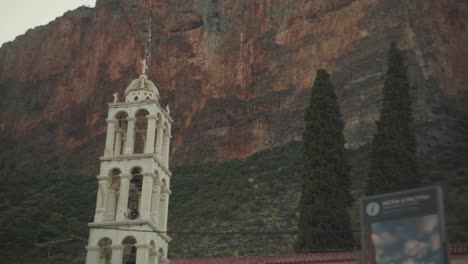 Vista-Estática-Hacia-Arriba-Del-Campanario-Del-Monasterio-O-De-La-Catedral-Contra-Acantilados-Rocosos-En-Leonidio,-Grecia