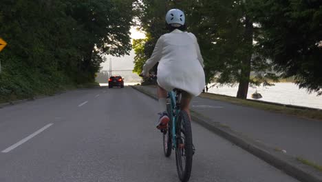 Radfahrerin-Mit-Helm-über-Asphaltierte-Straße