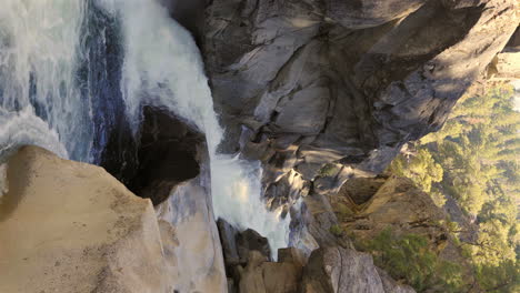 Fast-river-flowing-through-rocky-canyon,-vertical-video