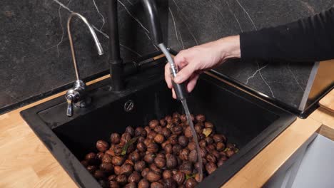 Washing-full-sink-of-walnuts-with-movable-tap-head