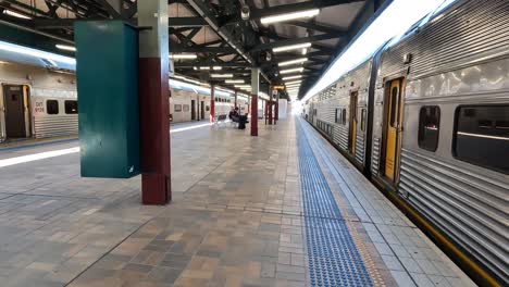 Clip-De-Mano-Caminando-En-La-Estación-Central-De-Sydney-Con-Vagones-Plateados-A-Ambos-Lados