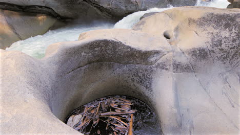 Underground-current-in-mountain-river-with-rocky-outcropping,-close-up