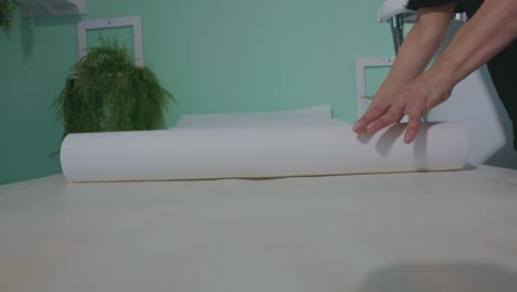 Professional-Masseuse-Covering-Massage-Table-With-Disposable-Sheet