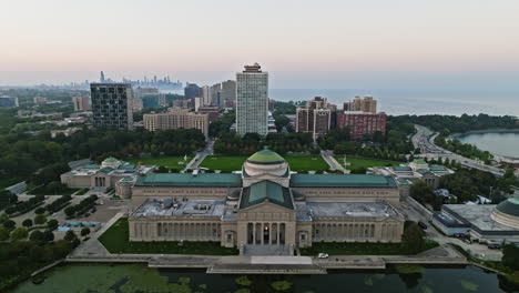 Aerial-view-rising-over-the-Museum-of-Science-and-Industry,-colorful-dawn-in-Chicago
