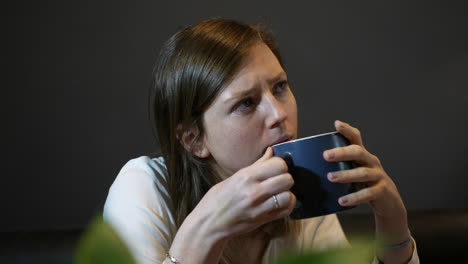 A-pensive-young-woman-drinking-coffee-from-a-cup-deep-in-though-thinking-about-a-problem