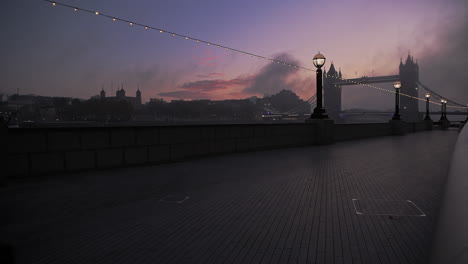 Tower-Bridge-and-River-Thames,-quiet-empty-and-deserted-at-sunrise-on-day-one-of-Coronavirus-Covid-19-lockdown-in-England-with-one-person-running-for-daily-exercise-in-the-UK