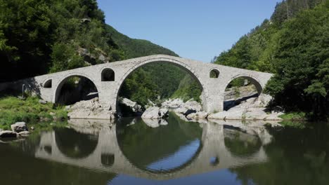 Annäherung-An-Einen-Drohnenschuss,-Der-Unter-Dem-Hauptbogen-Der-Teufelsbrücke-In-Ardino-Am-Fuße-Des-Rhodope-Gebirges-In-Bulgarien-Hindurchgeht