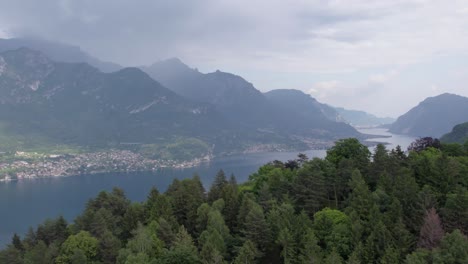 Der-Drohnenflug-über-Grünen-Wäldern-Zeigt-Den-Malerischen-Comer-See-In-Den-Italienischen-Alpen