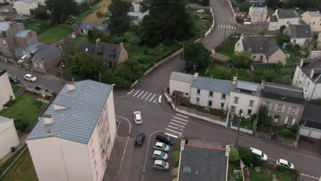 Drone-hovers,-tracks-car-in-French-suburb-scenic-drive
