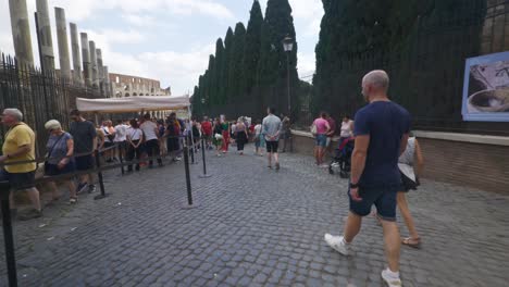 Punto-De-Vista-Inmersivo-En-Roma:-Moverse-Por-Calles-Concurridas-Hasta-Chiesa-Santi-Luca-E-Martina,-Italia,-Europa,-Caminar,-Tembloroso,-4k-|-Turistas-En-Fila-En-Ruinas-Cerca-Del-Coliseo