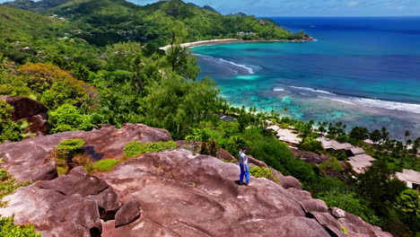 Vista-Aérea-De-Un-Excursionista-Disfrutando-De-La-Vista-De-La-Costa-Alta-En-La-Isla-Mahè,-Seychelles