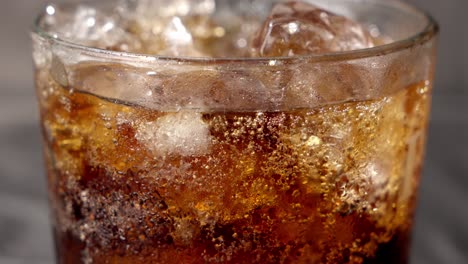 Coca-Cola,-glass-exudes-effervescence,-with-tiny-bubbles-clinging-to-sides