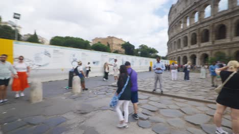 Rome-Immersive-POV:-Moving-In-Busy-Streets-to-Chiesa-Santi-Luca-e-Martina,-Italy,-Europe,-Walking,-Shaky,-4K-|-Tourist-Crowd-Waiting-on-Sidewalk-Near-Colosseum