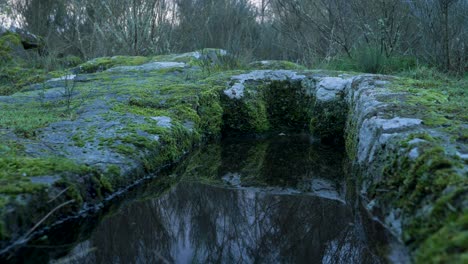 Low-angle-view-of-Anthropomorphic-burial-tombs-reflection-of-rocks-in-water