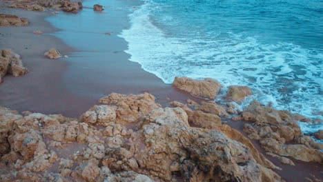 Die-Ungezähmte-Küste-Portugals-Zeichnet-Sich-Durch-Felsformationen-Aus,-Die-Von-Den-Ruhigen-Meereswellen-Bespritzt-Und-Vom-Strahlenden-Schein-Eines-Herrlichen-Tages-Beleuchtet-Werden