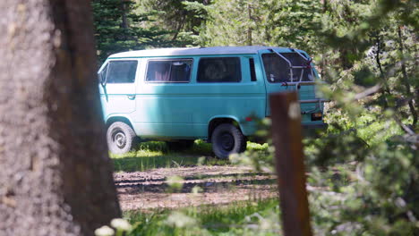 Vintage-Van-Parked-in-Sunlit-Forest-Clearing,-Pull-Focus