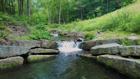 Drone-footage-of-a-beautiful-little-waterfall-stream-deep-in-the-Appalachian-mountains-on-a-warm,-green-summer's-day