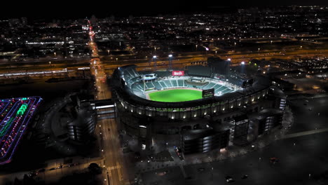 Aerial-view-around-the-illuminated-Guaranteed-Rate-Field,-nighttime-in-Chicago
