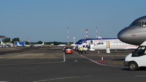 Cars-and-aircraft-on-Chișinău-airport-apron,-heavy-traffic,-summer-day-static