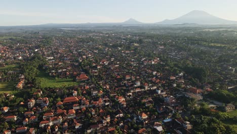 Establishing-shot-of-cultural-town-called-Ubud-with-the-view-at-volcano-Agung-at-the-background-during-sunrise-in-Bali,-Indonesia