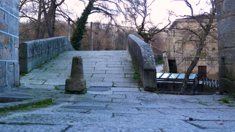 Niedriger-Blickwinkel-Auf-Den-Granitweg-Mit-Gras,-Das-Durch-Den-Riss-Der-Römischen-Brücke-Wächst