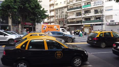 Black-and-Yellow-Taxi-Cars-Wait-at-Traffic-Light-Drive-under-Daylight-Avenue