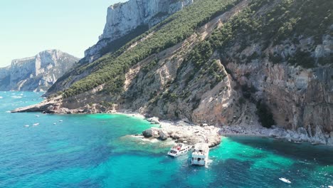 Ferry-Boats-at-Cala-Mariolu-beach-in-Sardinia,-Italy