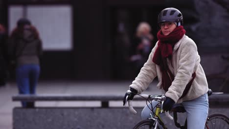 Slow-motion-footage-of-a-girl-cyclist-with-winter-outfit-riding-around-the-city