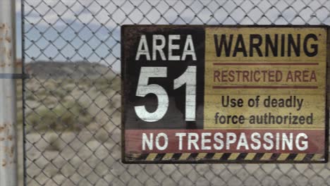 High-quality-3D-CGI-render-of-a-chainlink-fence-at-a-secret-military-installation-in-a-desert-scene,-with-an-Area-51-Warning-Restricted-Area-sign