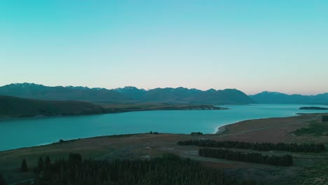 Drone-aerial-of-Lake-Tekapo-both-sides-of-lake-with-mountian-range-in-background