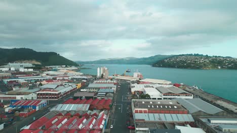 Drohnenflug-über-Die-Stadt-Dunedin-Mit-See-Und-Bergen-Im-Hintergrund