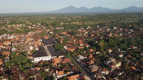 Establishing-shot-of-Ubud-downtown-with-traditional-Balinese-houses-and-volcanoes-at-the-background,-Bali,-Indonesia