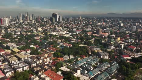 Aerial-birds-eye-shot-of-housing-area-in-Manila-and-Skyline-lighting-by-sunset-light