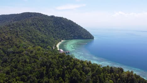 Aufsteigende-Luftaufnahme-Einer-Exotischen,-Abgeschiedenen-Bucht-Einer-Abgelegenen-Tropischen-Insel,-Die-Von-Dichtem-Regenwald-In-Raja-Ampat,-West-Papua,-Indonesien,-Bedeckt-Ist