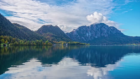 Mountain-landscape-reflecting-on-calm-lake-water-surface,-time-lapse-view