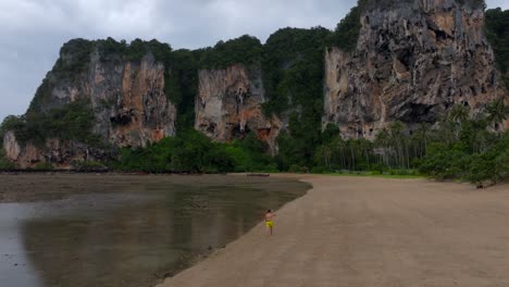 Drone-footage-from-Railay-beach-in-Krabi-Thailand-footage-of-incredible-Thai-landscapes-incredible-nature-with-insane-rocks,-beaches,-hills,-ocean,-and-a-model-man-walking